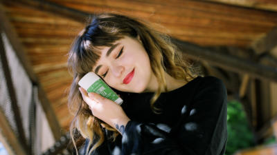 woman holding schmidt's jasmine tea sensitive skin next to her face
